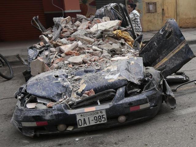 People walk past a car squashed by rubble after a 7.8-magnitude quake in Portoviejo, Ecuador. (AFP Photo) People walk past a car squashed by rubble after a 7.8-magnitude quake in Portoviejo, Ecuador. (AFP Photo)