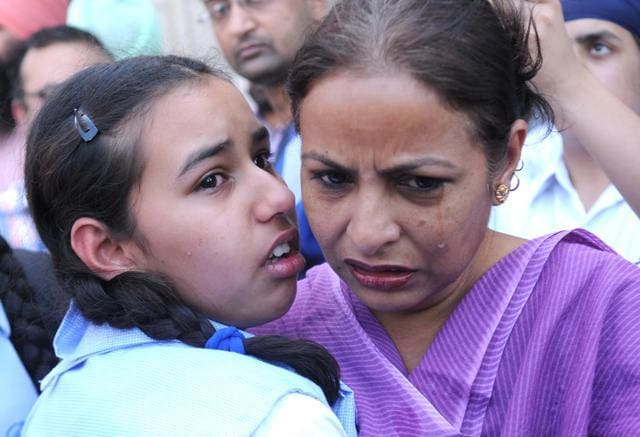 A woman and child shaken after a Patiala school detained students for non-payment of a disputed fee. A woman and child shaken after a Patiala school detained students for non-payment of a disputed fee.