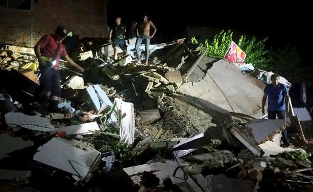 People stand next to the debris of a building in Manta, Ecuador. The quake struck early evening at a depth of 20 km (12.4 miles), and was felt all around the country. (REUTERS) People stand next to the debris of a building in Manta, Ecuador. The quake struck early evening at a depth of 20 km (12.4 miles), and was felt all around the country. (REUTERS)