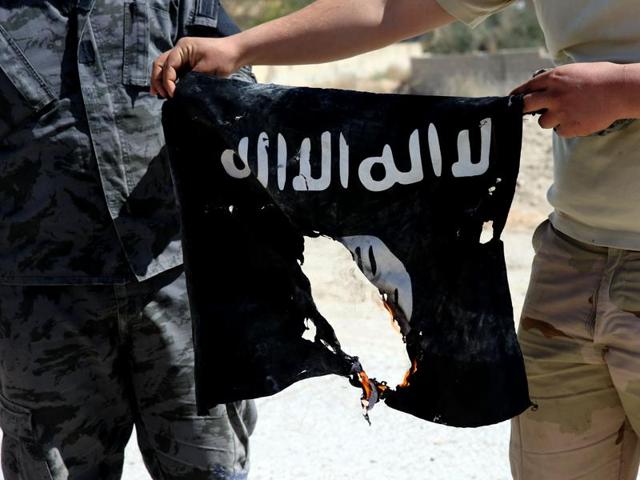 Iraqi soldiers hold a flag that they seized from the Islamic State group. (AFP Photo) Iraqi soldiers hold a flag that they seized from the Islamic State group. (AFP Photo)