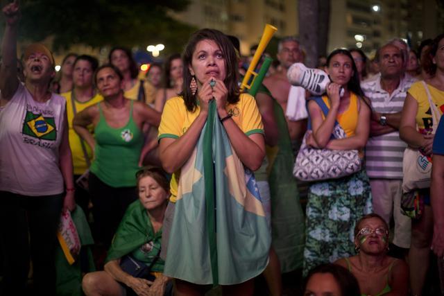 An anti-government demonstrator holds a Brazilian flag as she watches the vote count on a screen, as lawmakers vote on whether or not to impeach President Dilma Rousseff on Copacabana beach, in Rio de Janeiro, Brazil. (AP Photo) An anti-government demonstrator holds a Brazilian flag as she watches the vote count on a screen, as lawmakers vote on whether or not to impeach President Dilma Rousseff on Copacabana beach, in Rio de Janeiro, Brazil. (AP Photo)