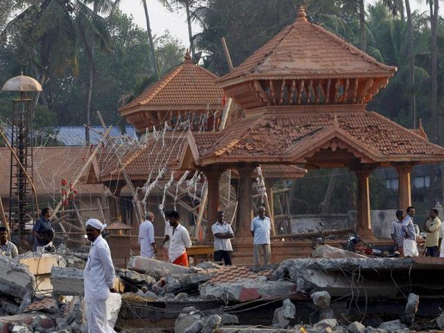 People take stock of the damaged structure of the Puttingal Devi temple after the fire accident that claimed more than 100 lives.(PTI File Photo)