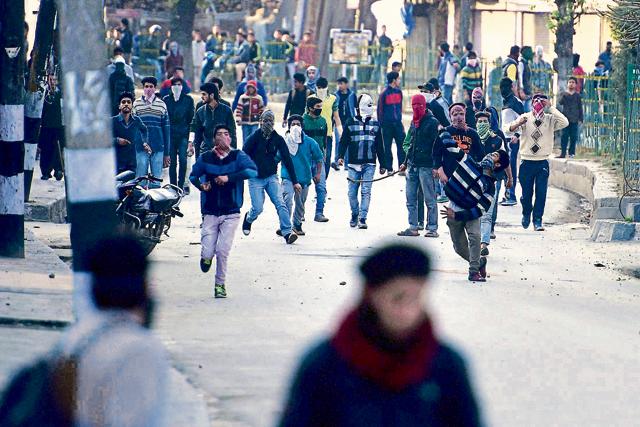 Angry youngsters throw stones at police personnel as an agitation turns violent in downtown Srinagar. (PTI photo) Angry youngsters throw stones at police personnel as an agitation turns violent in downtown Srinagar. (PTI photo)