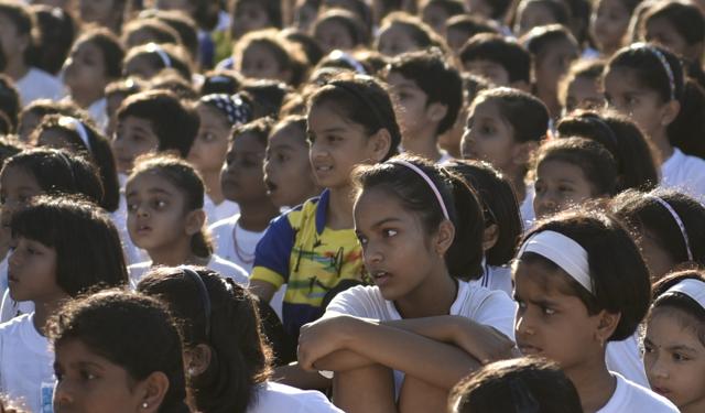 Children watching as a gymnast of Samarth Vyayam Mandir demonstrates her skill  to the students and parents during the opening ceremony of a summer camp at Dadar in Mumbai, India, on Sunday.  (satish bate/Hindustan Times) 