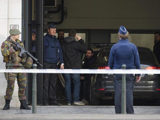 A Belgian police officer secures the zone outside a courthouse while Brussels attacks suspects Mohamed Abrini and Osama Krayem appear before a judge, in Brussels, Belgium.(REUTERS)