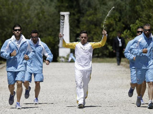 Greek gymnast Eleftherios Petrounias carries a torch with the Olympic flame during the ceremonial lighting of the Olympic flame in Ancient Olympia, Greece. (AP Photo)