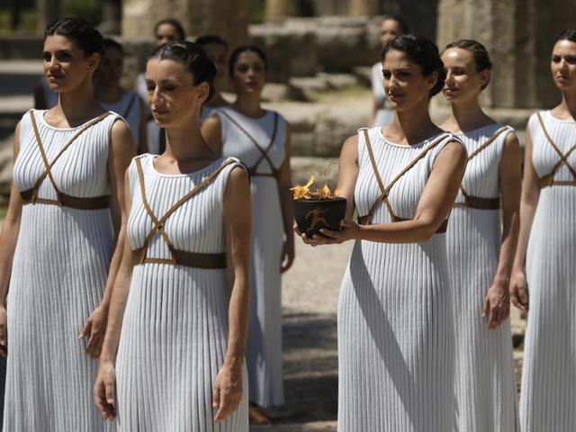 Dancers dressed as priestesses hold the Olympic flame during the ceremonial lighting of the Olympic flame in Ancient Olympia, Greece. (AP Photo)