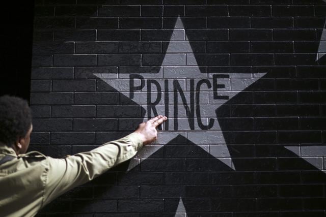 After kissing his fingers, a fan touched Prince's star on the wall of First Ave., Thursday, April 21, 2016. (AP) After kissing his fingers, a fan touched Prince's star on the wall of First Ave., Thursday, April 21, 2016. (AP)