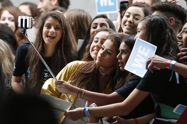 Singer Selena Gomez poses for a selfie stick photo with students as she arrives at We Day California in Inglewood, California, April 7, 2016. (REUTERS)