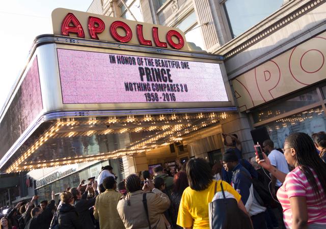 People gather outside the Apollo Theater to listen to music by Prince April 21, 2016 in New York. (AFP) People gather outside the Apollo Theater to listen to music by Prince April 21, 2016 in New York. (AFP)