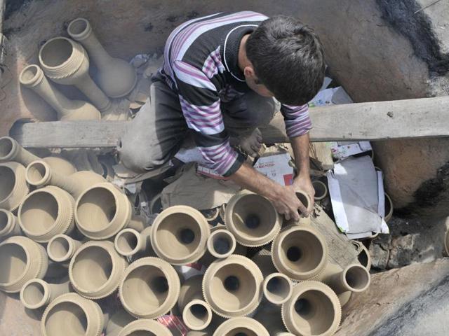 A potter arranging set of Tumbaknaris for baking in a furnace. (Waseem Andrabi/ HT)