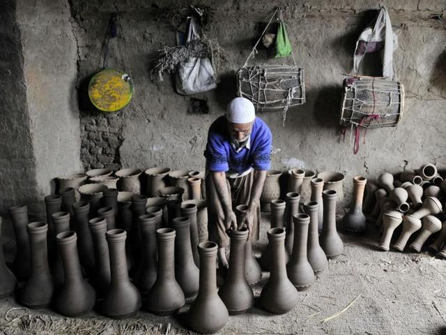 A Kashmiri potter adjusts freshly-made earthen Tumbaknaris, a Kashmiri musical drum. (Waseem Andrabi/ HT)