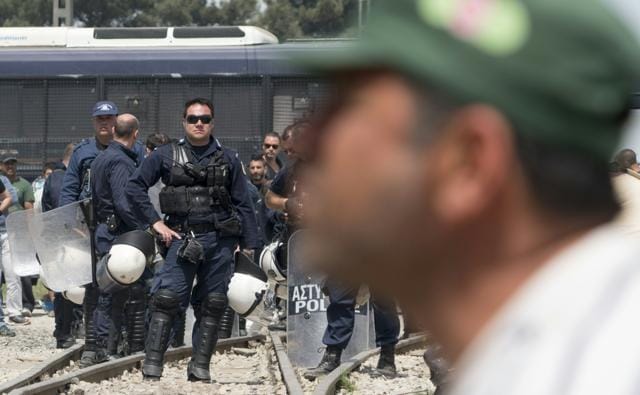 Greek police gather at the railway tracks at a makeshift camp for migrants and refugees near Idomeni. (AFP)