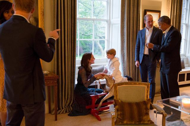 Prince George on his rocking horse as Duchess Catherine talks to him, while Obama and Prince Williams share a chat. (Reuters)