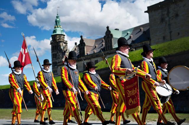 People dressed in old uniforms walk in front of Kronborg Castle in Helsingor on April 23, 2016. Kronborg Castle was the setting for Shakespeare's Hamlet. (AFP Photo)