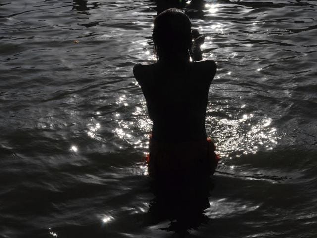 A Naga sadhu offers prayers after taking a holy dip in the Shipra river in Ujjain.(Shankar Mourya/HT Photo)