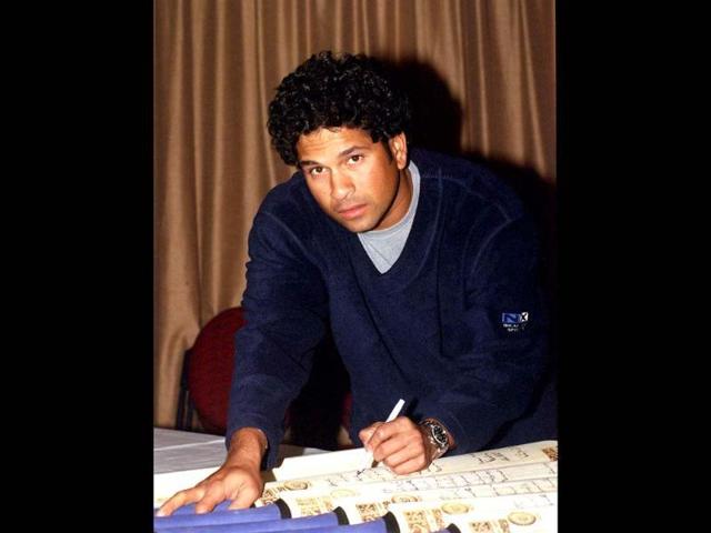 Sachin signs cricket bats for fans. The status he enjoys in India is literally godlike. Getty Images.
