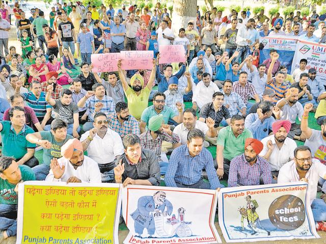 Holding posters, parents raising slogans against private schools and the district administration in Amritsar on Sunday.(Sameer Sehgal/HT)