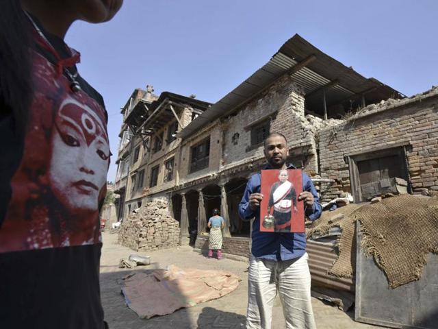 A villager shows the image of his mother who succumbed to her injuries in the earthquake. (Raj K Raj/Hindustan Times) 
