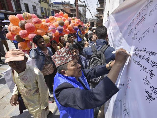 Nepalese people write messages in memory of their loved ones on the first anniversary of the 2015 earthquake at Darbar Square. (Raj K Raj/Hindustan Times) 