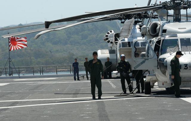 Helicopter crew members of Japan's helicopter carrier Ise stand on the deck shortly after arriving at Subic port, north of Manila, on Tuesday. Ise is in the Philippines for a four-day goodwill visit, near disputed South China Sea waters, where Beijing's increasingly assertive behaviour has sparked global concern. (AFP)