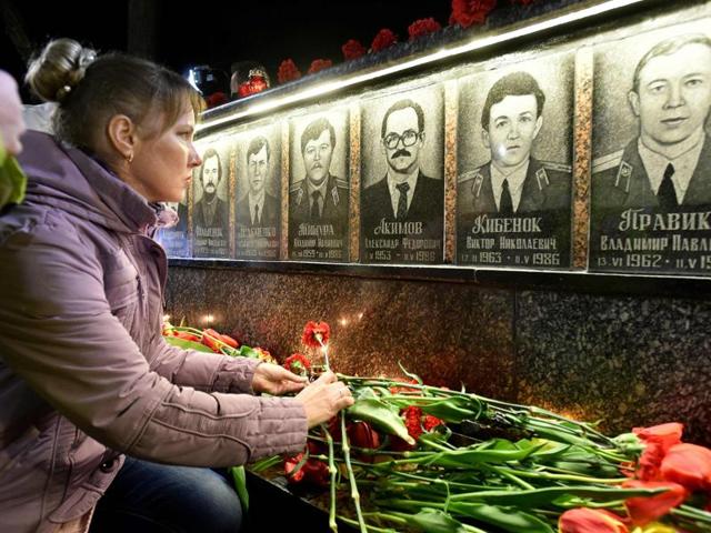 A woman places a flower in front of the monument to Chernobyl victims in Slavutich, some 50 kilometres (30 miles) from the accident site during a memorial ceremony. (AFP Photo)