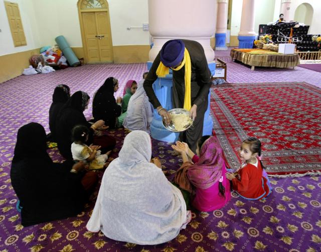 Pakistani Sikhs receive parshad or holy food distributed by a man, at the 300-year-old gurdwara or place of worship in Peshawar, Pakistan. Earlier this month, the gurdwara in Peshawar’s crowded Old City opened its doors to worshippers for the first time in 73 years. (AP Photo) Pakistani Sikhs receive parshad or holy food distributed by a man, at the 300-year-old gurdwara or place of worship in Peshawar, Pakistan. Earlier this month, the gurdwara in Peshawar’s crowded Old City opened its doors to worshippers for the first time in 73 years. (AP Photo)