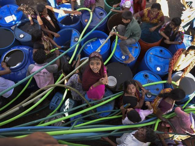 The long wait for water has become a part of life for villagers. They queue up hours before a tanker arrives in their area, which is only once in seven days. (Satish Bate/Hindustan Times)