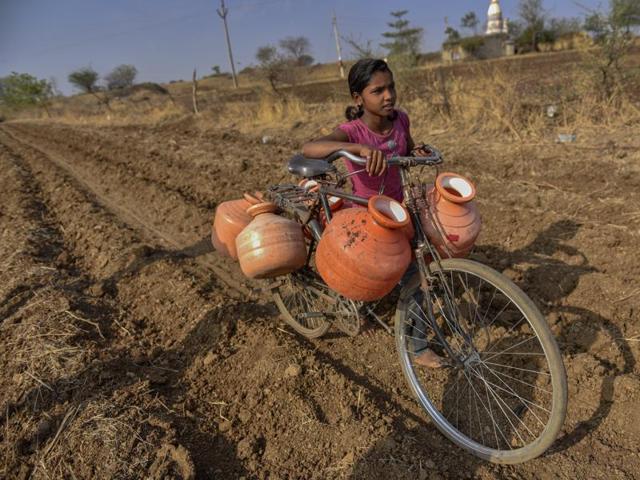 Little girls and boys are forced to miss school so they can fetch water from kilometres away. On April 20, a 12-year-old girl succumbed to the heatwave, after making multiple trips to get water for her family. (Satish Bate/Hindustan Times)
