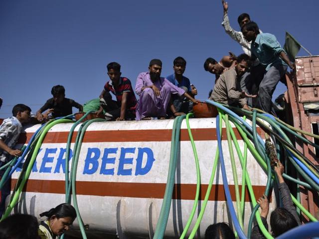 Villagers scramble around a tanker for potable water in Beed. A ‘water train’ is also making regular trips to Latur, to alleviate the scarcity. (Satish Bate/Hindustan Times)