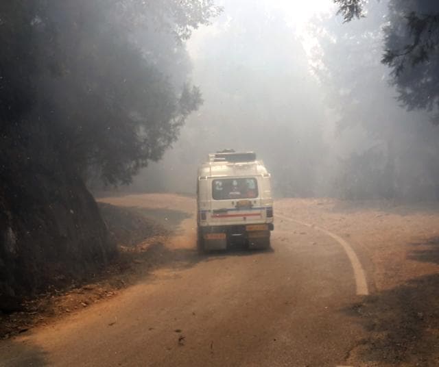A vehicles moves along a road as smoke reduces visibility. (Arvind Moudgil /HT Photo) A vehicles moves along a road as smoke reduces visibility. (Arvind Moudgil /HT Photo)