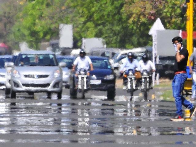 A mirage forms on the roads of Chandigarh  due to heat as vehicles pass through it.   (Keshav Singh/HT Photo) 