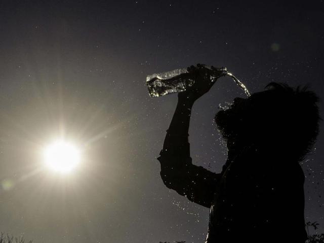 A boy pours water on his face to get some relief  from the heat.   (Karun Sharma/HT Photo) 