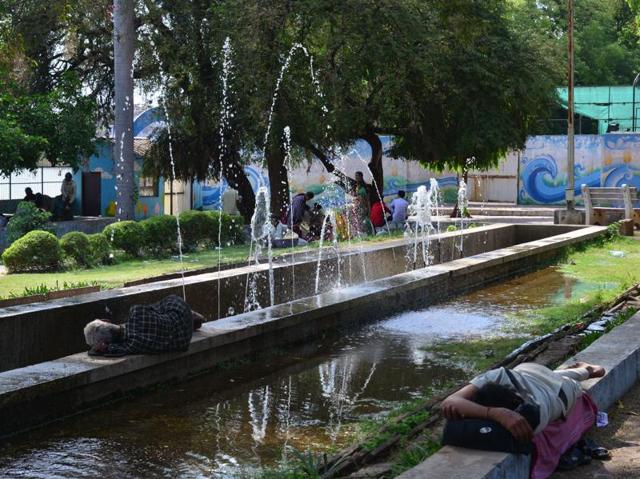 People take nap on a hot day near a fountain at Neelam park in Bhopal. (Mujeeb Faruqui/HT Photo) 