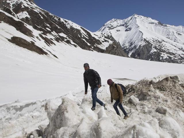 Kashmiri civilians walks on a snow covered field near the Zojila Pass. Although, the road was cleared by March 16, fresh snowfall later that month again rendered it unmotorable. (AP) Kashmiri civilians walks on a snow covered field near the Zojila Pass. Although, the road was cleared by March 16, fresh snowfall later that month again rendered it unmotorable. (AP)