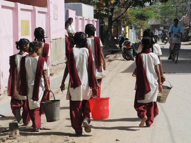 Students of state governments upgraded Urdu Hindi Primary School walk to collect water during school hours as the bore well on the campus dried up  two months ago.   (Parwaz Khan/HT Photo) 