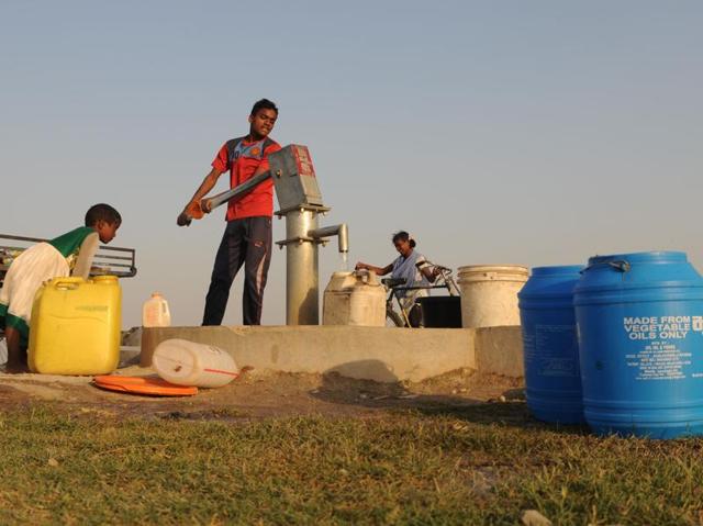 Children the containers with water using a hand pump as many parts in Ranchi face a water crisis.   (Parwaz Khan/HT Photo) 