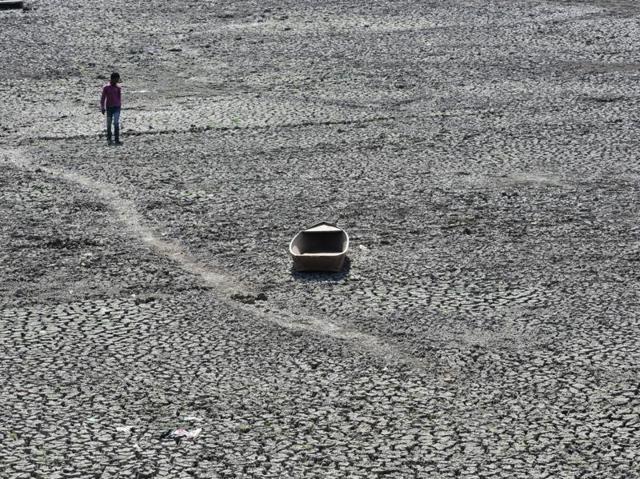 A boat lies in the middle of the dried up lake of Prithvipur town as drought hits Bundelkhand. (Mujeeb Faruqui/HT Photo) 