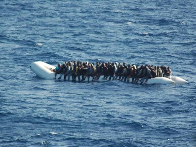 This handout file picture released by the Italian Navy (Marina Militare) on March 16, 2016 shows migrants and refugees seated on an inflatable boat during a rescue operation of at sea. An Italian cargo ship rescued 26 migrants from a flimsy boat that was sinking off the coast of Libya but 84 people may be missing.(AFP File Photo)