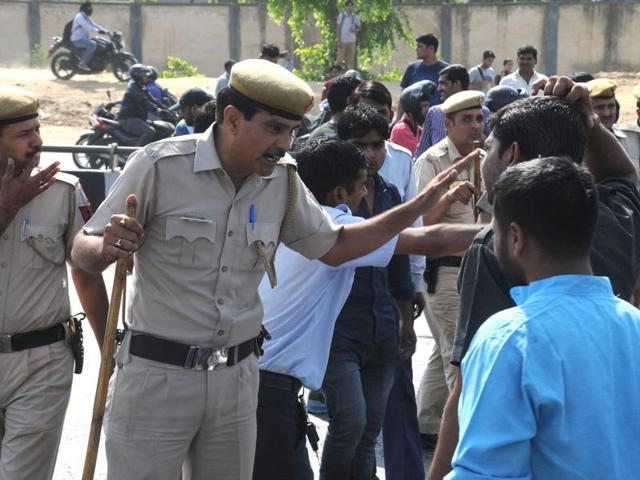 Policemen cane taxi drivers protesting the ban.  Taxi drivers blocked key intersections in Delhi and neighbouring Gurgaon on Monday morning, bringing peak-hour traffic to a standstill for hours. (Parveen Kumar/HT Photo) 