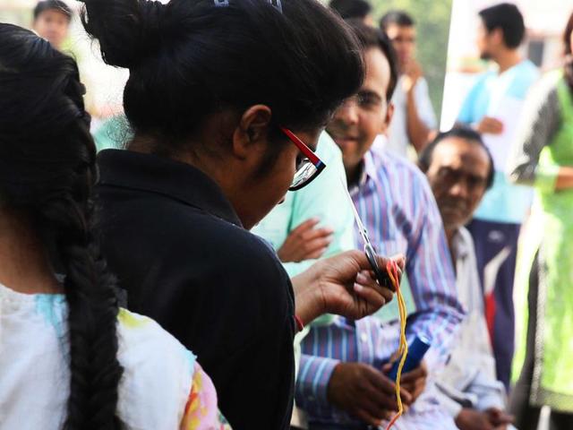 A candidate appearing in the National Eligibility cum Entrance Test takes off sacred thread tied on her wrist as per official instructions, prior to entering the examination center in Jaipur, Rajasthan on Sunday. (Hindustan Times) A candidate appearing in the National Eligibility cum Entrance Test takes off sacred thread tied on her wrist as per official instructions, prior to entering the examination center in Jaipur, Rajasthan on Sunday. (Hindustan Times)