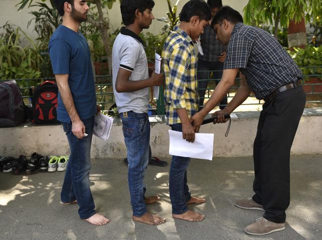 The candidates were also asked to take off their shoes before being scanned with a metal detector and torchlight. Girls had to tie their hair. (Vipin Kumar/HT Photo) The candidates were also asked to take off their shoes before being scanned with a metal detector and torchlight. Girls had to tie their hair. (Vipin Kumar/HT Photo)