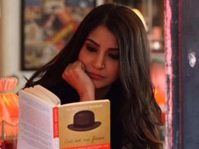Filmmaker Karan Johar has shared a picture that shows Anushka Sharma reading The Man Who Mistook His Wife For A Hat by Oliver Sacks in what appears to be a cafe.(Twitter)