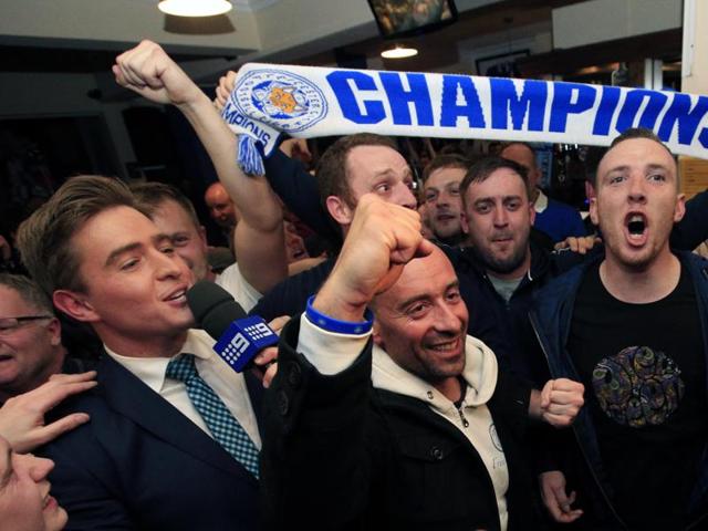 Leicester City fans celebrate in the Market Tavern in Leicester after seeing their side crowned English Premier League soccer champions following Tottenham Hotspur's 2-2 draw against Chelsea. (AP) Leicester City fans celebrate in the Market Tavern in Leicester after seeing their side crowned English Premier League soccer champions following Tottenham Hotspur's 2-2 draw against Chelsea. (AP)