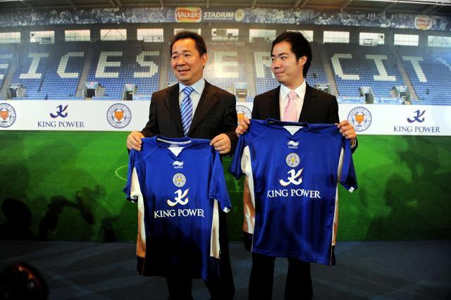 Chairman and CEO of Thailand's King Power, Vichai Raksriaksorn (L) and his son Aiyawatt Raksiaksorn (R), hold jerseys of England's Leicester City football club during a takeover announcement in Bangkok. (AFP File Photo)