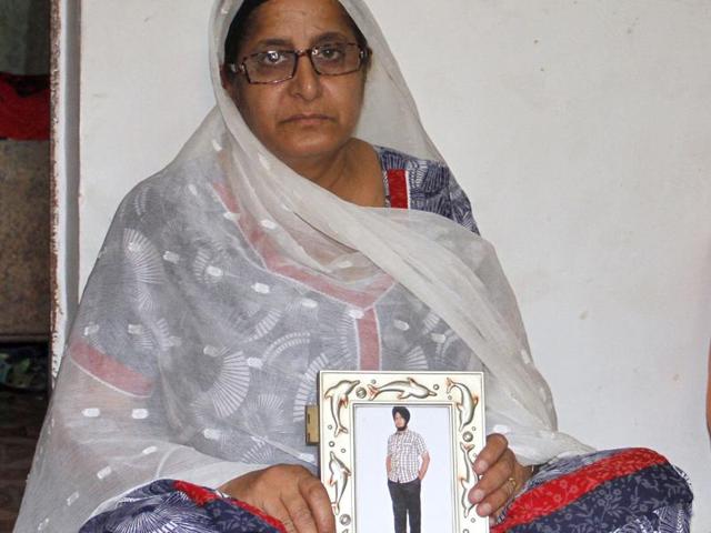 The mother of Inderpal Ahuja holding his photograph at her home in Ludhiana.(JS Grewal/HT Photo) The mother of Inderpal Ahuja holding his photograph at her home in Ludhiana.(JS Grewal/HT Photo)