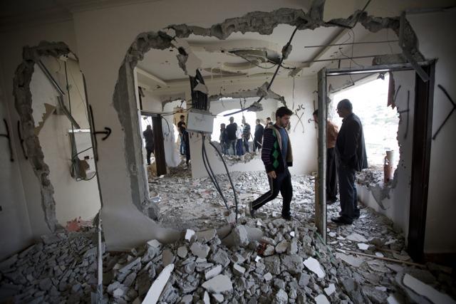 Palestinians inspect the damaged house of Zaid Amer (AP)
