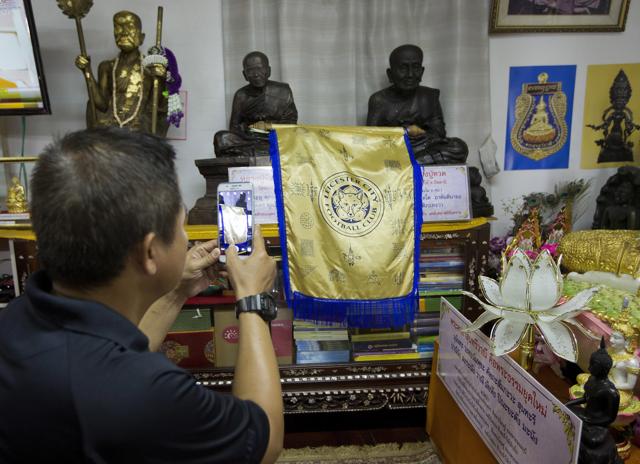 A visitor photographs a Leicester City banner at the Wat Traimitr Withayaram temple in Bangkok. (AP) A visitor photographs a Leicester City banner at the Wat Traimitr Withayaram temple in Bangkok. (AP)