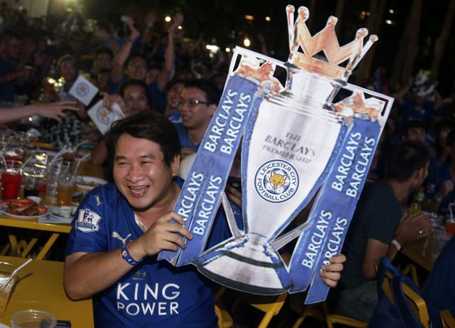 A Thai supporter of Leicester City reacts as people watch the English Premier League soccer match between Leicester City and Manchester United on the TV, in Bangkok, Thailand. (AP)