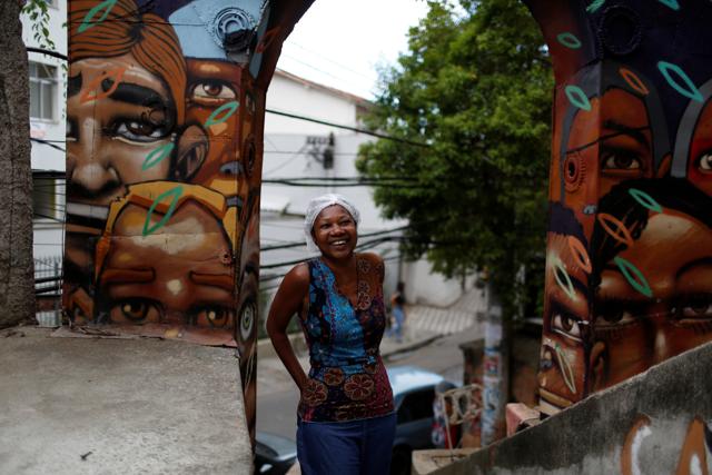 In recent times, there has been a growing interest in favelas as tourist locations. Ligia, the owner of Pousada Favela Cantagalo hostel, poses for a photograph near her hostel. (REUTERS) 